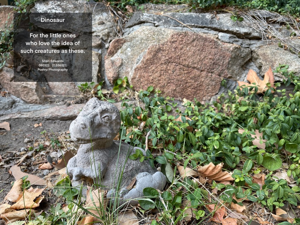 sculpture of dinosaur hatching in a rock garden