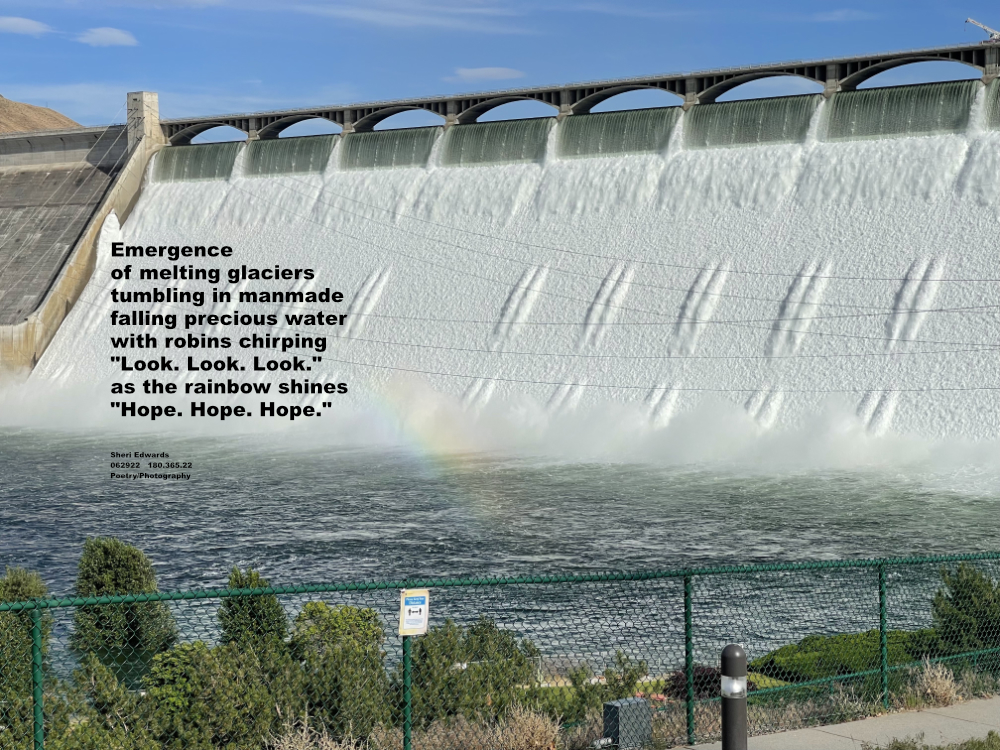water flowing over Grand Coulee Dam with part of rainbow