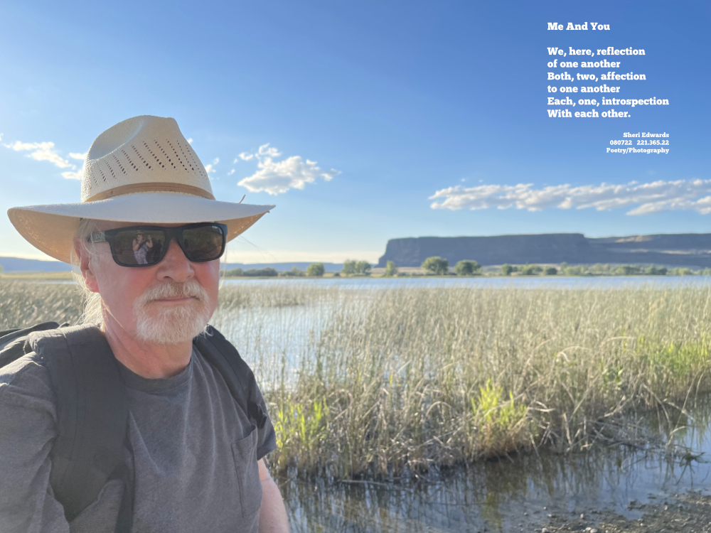 Man with Panama straw hat and black sunglases by the cattails by the lake