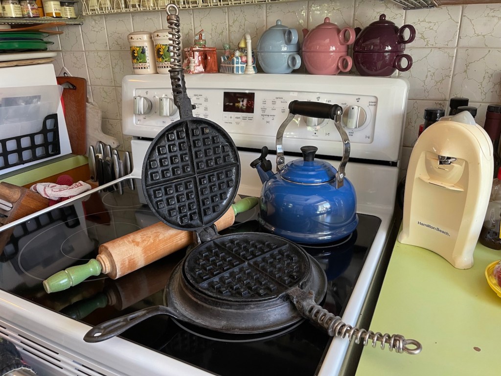 old cast-iron waffle maker pan and an old rolling pin
